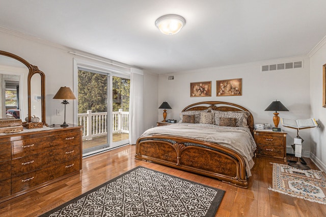 bedroom featuring access to exterior, hardwood / wood-style floors, and ornamental molding