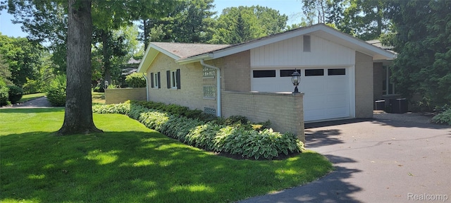 4678 Brightmore Rd, Bloomfield Hills, MI 48302 - view of side of home featuring driveway, brick siding, a garage, and a yard
