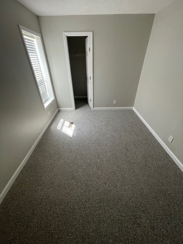 carpeted spare room featuring baseboards