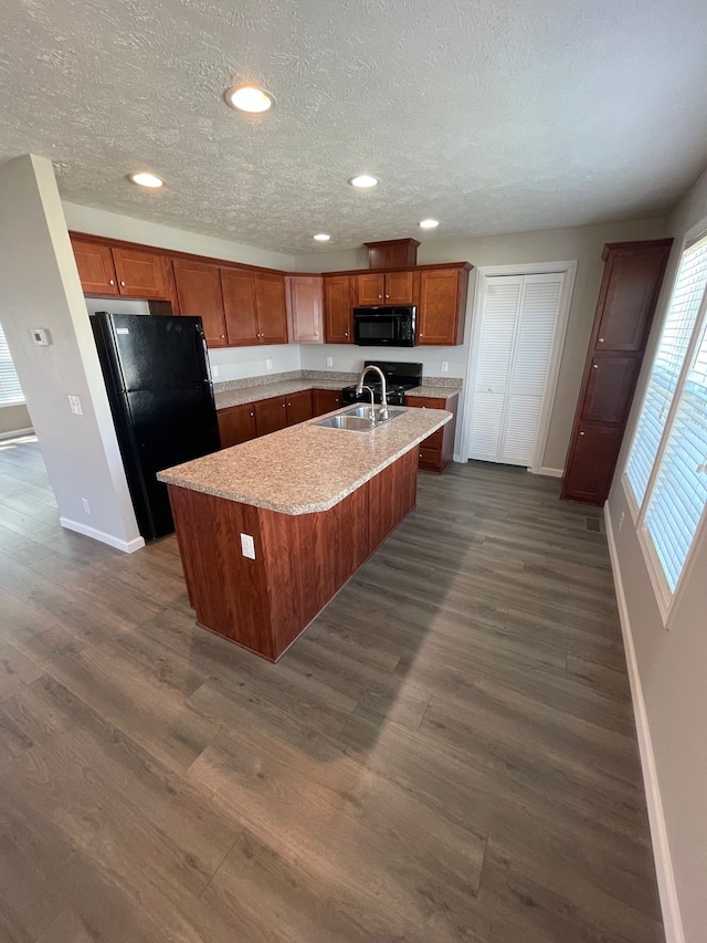 kitchen with black appliances, baseboards, a sink, brown cabinets, and dark wood-type flooring