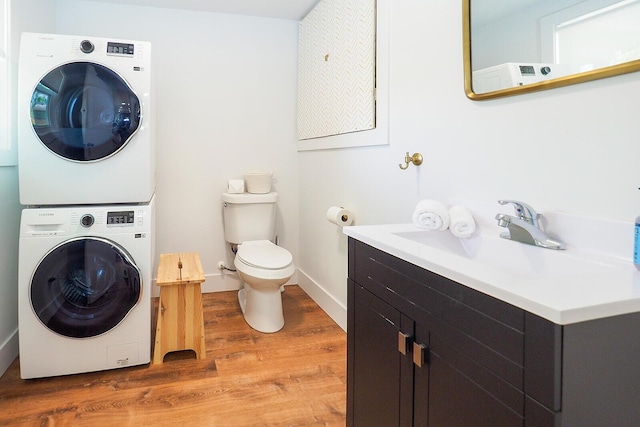 10671 California Rd, Bridgman, MI 49106 - half bath with stacked washing machine and dryer, wood finished floors, toilet, baseboards, and vanity