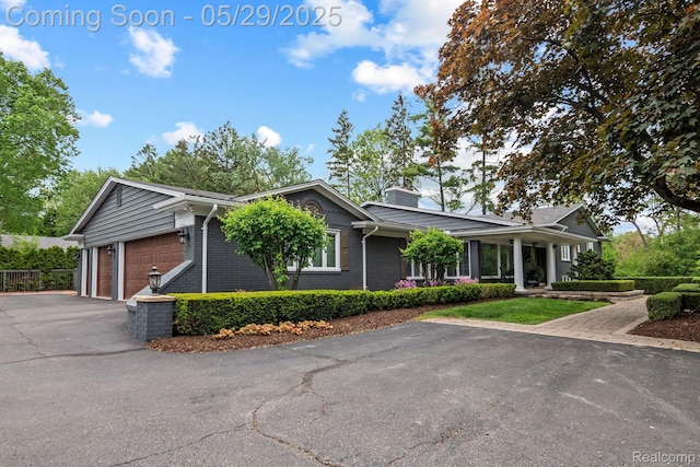 4906 Charing Cross Rd, Bloomfield Hills, MI 48304 - ranch-style home featuring asphalt driveway, brick siding, and a chimney