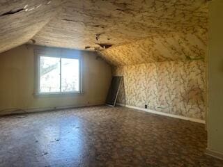 bonus room with baseboards and lofted ceiling