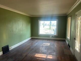 unfurnished room with baseboards, ornamental molding, and wood finished floors