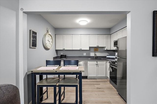 16046 Holz Dr Unit 48, Southgate, MI 48195 - kitchen with a sink, light wood-style flooring, appliances with stainless steel finishes, and white cabinets