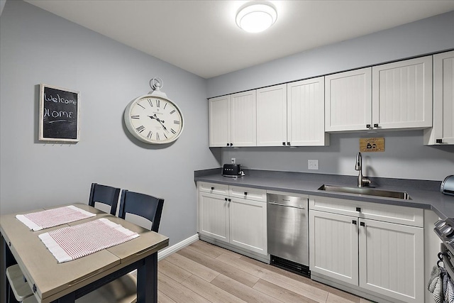 16046 Holz Dr Unit 48, Southgate, MI 48195 - kitchen with a sink, dark countertops, light wood-style flooring, stove, and stainless steel dishwasher