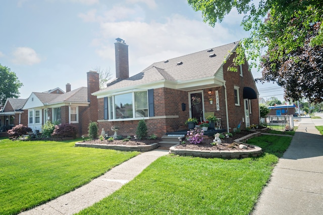 13185 Sycamore St, Southgate, MI 48195 - view of front of house with brick siding, a front yard, a chimney, and roof with shingles