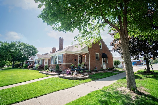 13185 Sycamore St, Southgate, MI 48195 - view of front of home with brick siding, a front yard, and a chimney