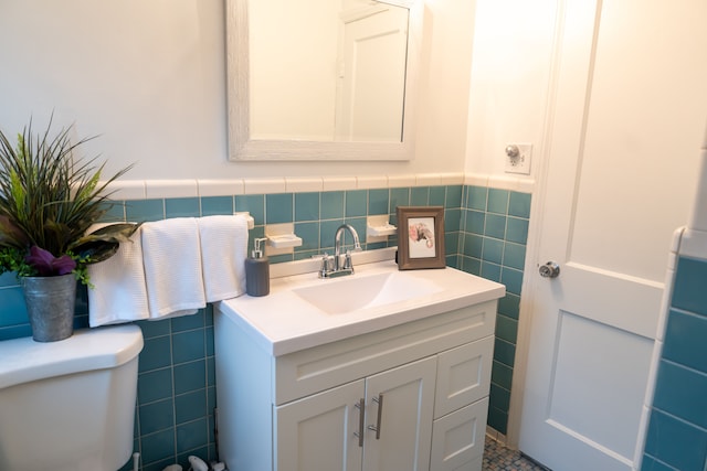 13185 Sycamore St, Southgate, MI 48195 - bathroom featuring tile walls, vanity, toilet, and wainscoting