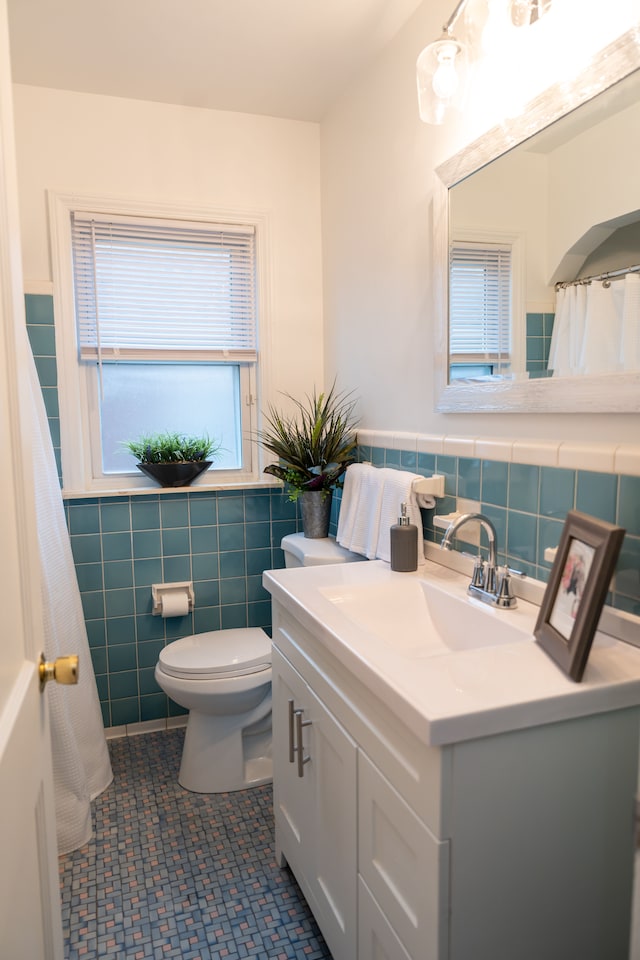 13185 Sycamore St, Southgate, MI 48195 - full bath with tile walls, toilet, vanity, and a wainscoted wall