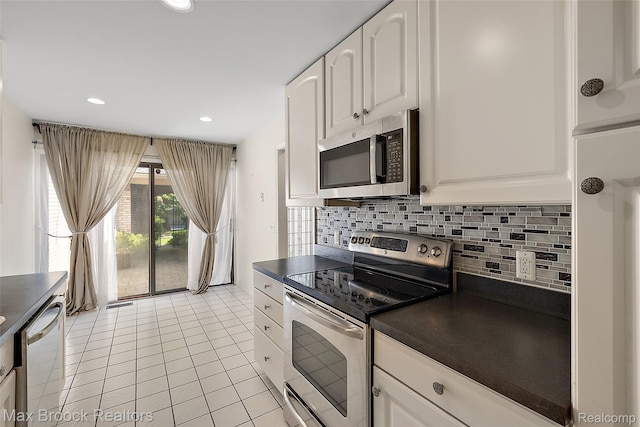 1461 Woodglen Ln Unit G-28, Bloomfield Hills, MI 48304 - kitchen with stainless steel appliances, dark countertops, light tile patterned floors, tasteful backsplash, and white cabinets