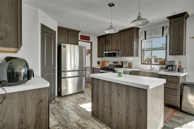 7376 Capac Rd, Yale, MI 48097 - kitchen featuring appliances with stainless steel finishes, a sink, light wood-style flooring, tasteful backsplash, and dark brown cabinetry