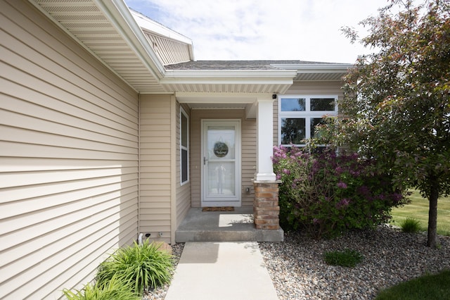 property entrance featuring a shingled roof