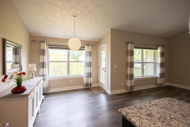 dining space featuring plenty of natural light, dark wood finished floors, and baseboards