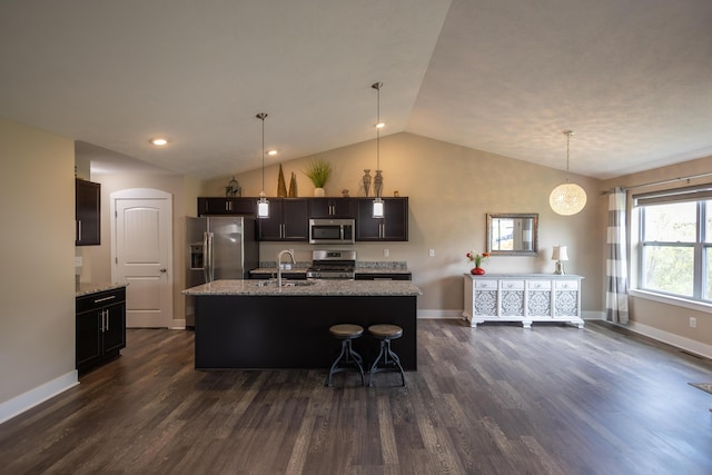 kitchen with appliances with stainless steel finishes, a sink, vaulted ceiling, dark wood-style flooring, and baseboards