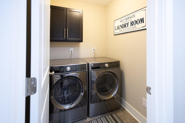 washroom featuring washing machine and dryer, cabinet space, tile patterned flooring, and baseboards