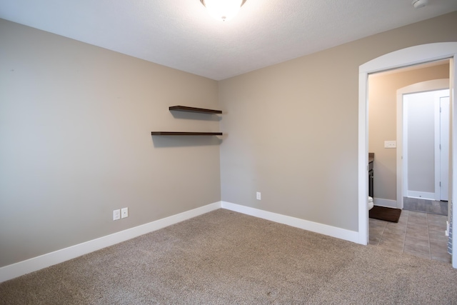 unfurnished room with carpet flooring and baseboards