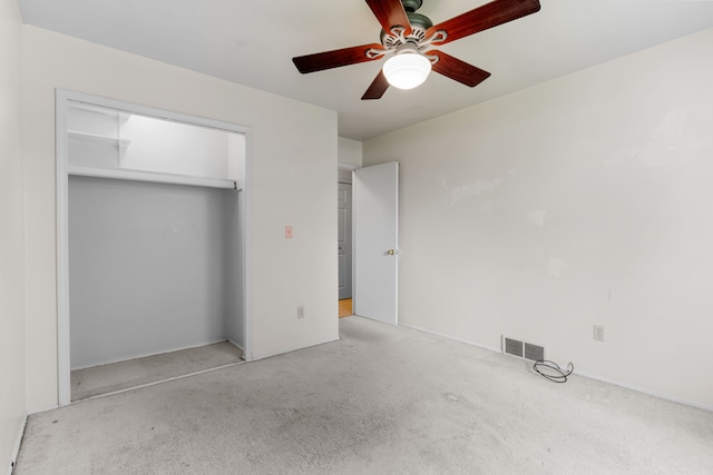unfurnished bedroom featuring carpet, a ceiling fan, and a closet