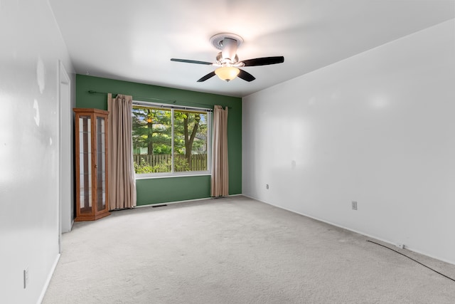 carpeted empty room featuring a ceiling fan