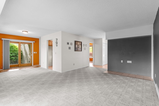 unfurnished living room featuring a textured ceiling and carpet floors
