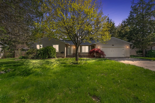 ranch-style house with a garage, driveway, and a yard