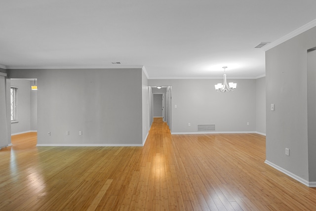 unfurnished living room with a chandelier, light wood-style floors, baseboards, and ornamental molding