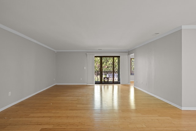 unfurnished room featuring baseboards, light wood-style flooring, and crown molding