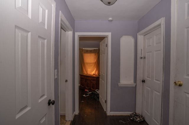 hallway with baseboards and wood finished floors