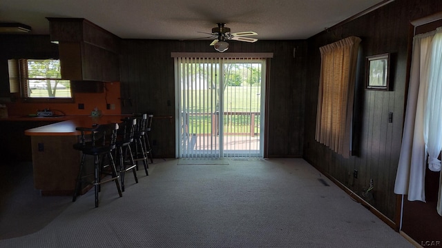11800 N Adrian Hwy, Clinton, MI 49236 - dining space featuring a ceiling fan, light colored carpet, and wood walls