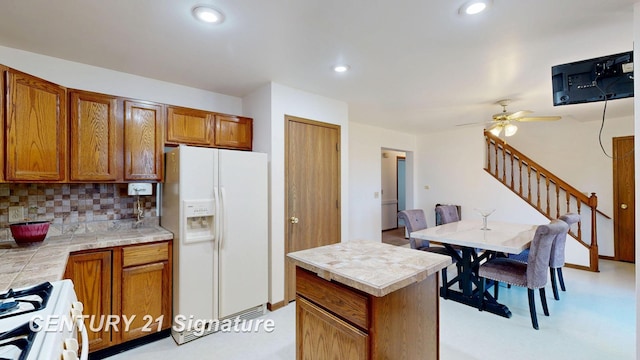 5530 Hess Rd, Saginaw, MI 48601 - kitchen with white refrigerator with ice dispenser, gas stove, brown cabinets, tasteful backsplash, and recessed lighting