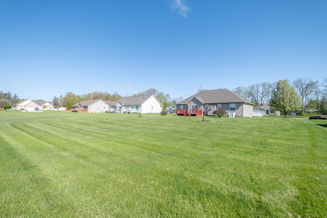 view of grassy yard with a residential view