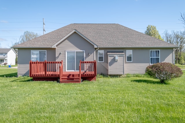 rear view of property with a shingled roof, a deck, and a yard