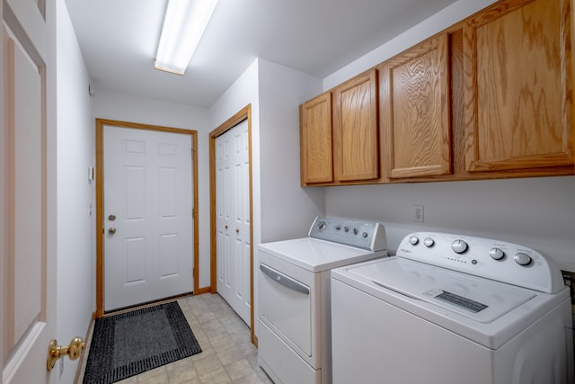 laundry room with cabinet space, washing machine and dryer, and light floors