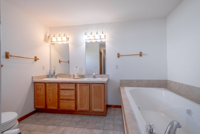 bathroom with a bath, toilet, double vanity, and baseboards
