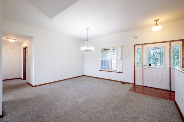 entryway with carpet floors, a chandelier, and baseboards