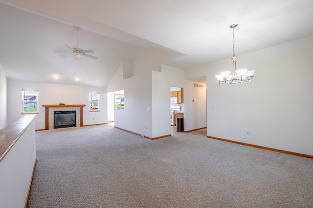 unfurnished living room with plenty of natural light, baseboards, light colored carpet, and high vaulted ceiling