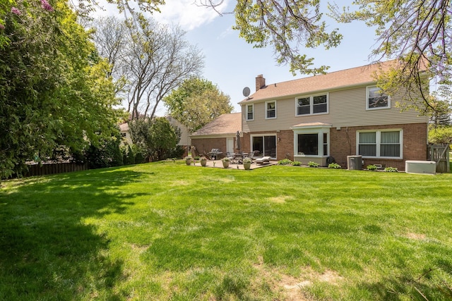 rear view of house featuring a chimney, brick siding, a patio, central air condition unit, and an outdoor hangout area