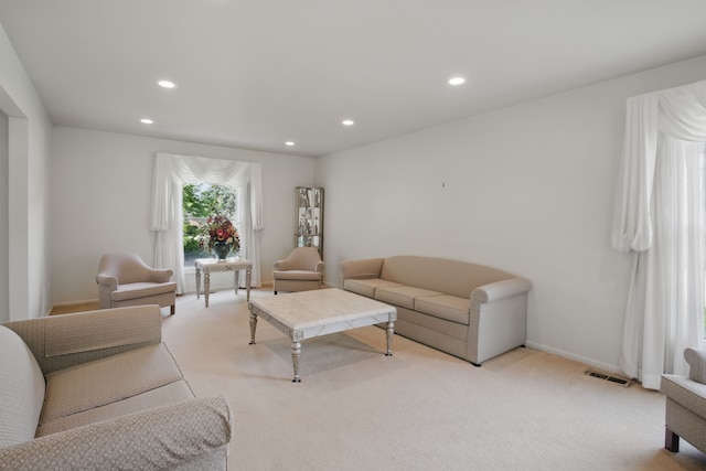 living room featuring light colored carpet, recessed lighting, and baseboards