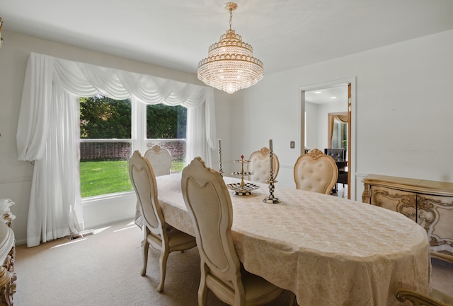 dining area featuring a chandelier and carpet floors