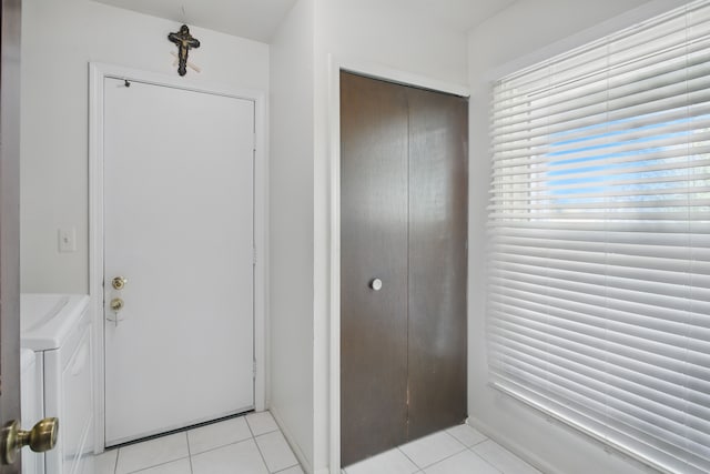 foyer with independent washer and dryer and light tile patterned floors