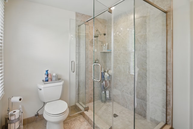 bathroom featuring a stall shower and toilet