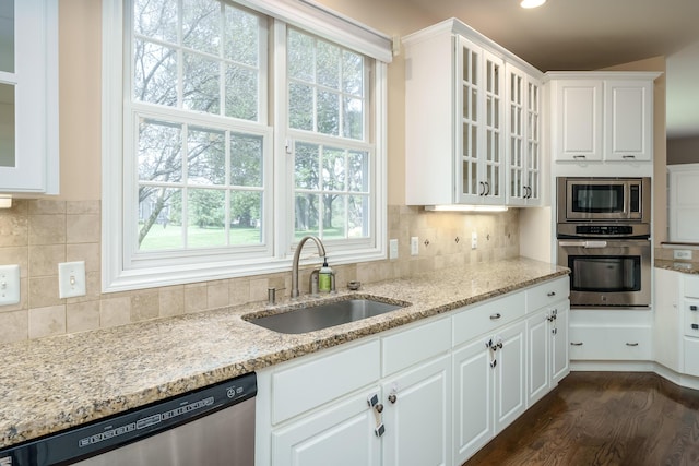 7294 Mackenzie Ln, Portage, MI 49024 - kitchen featuring appliances with stainless steel finishes, a sink, white cabinetry, light stone countertops, and dark wood-style floors