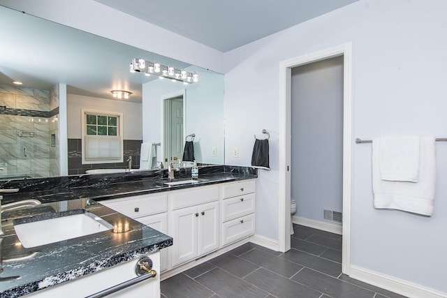 7294 Mackenzie Ln, Portage, MI 49024 - bathroom featuring a shower stall, toilet, double vanity, and baseboards