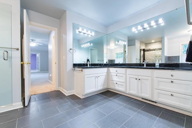 7294 Mackenzie Ln, Portage, MI 49024 - bathroom featuring a shower stall, double vanity, ceiling fan, baseboards, and tile patterned floors