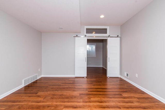 7294 Mackenzie Ln, Portage, MI 49024 - unfurnished room with wood finished floors, recessed lighting, baseboards, and a barn door