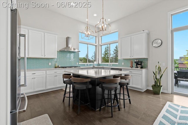 10611 Stoney Point Dr, South Lyon, MI 48178 - kitchen featuring wall chimney range hood, a chandelier, light countertops, decorative backsplash, and freestanding refrigerator