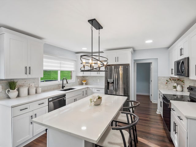 4206 Southmoor Ln, West Bloomfield, MI 48323 - kitchen featuring stainless steel appliances, a sink, decorative backsplash, a kitchen breakfast bar, and light countertops