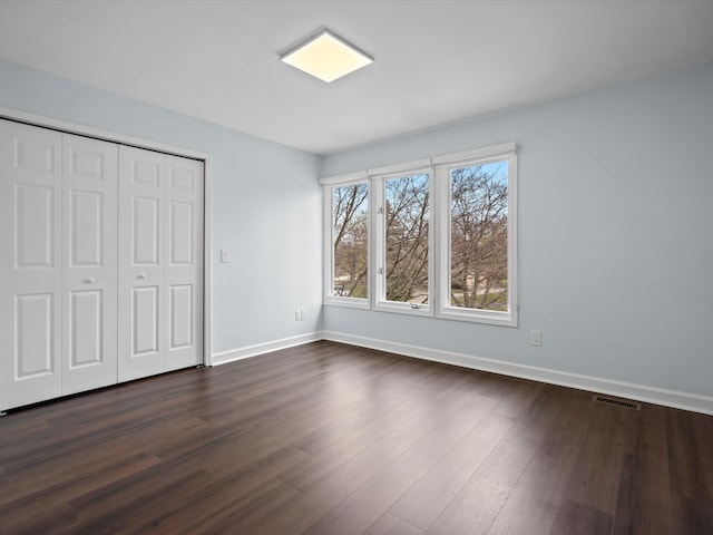 4206 Southmoor Ln, West Bloomfield, MI 48323 - unfurnished bedroom featuring baseboards, dark wood-type flooring, and a closet