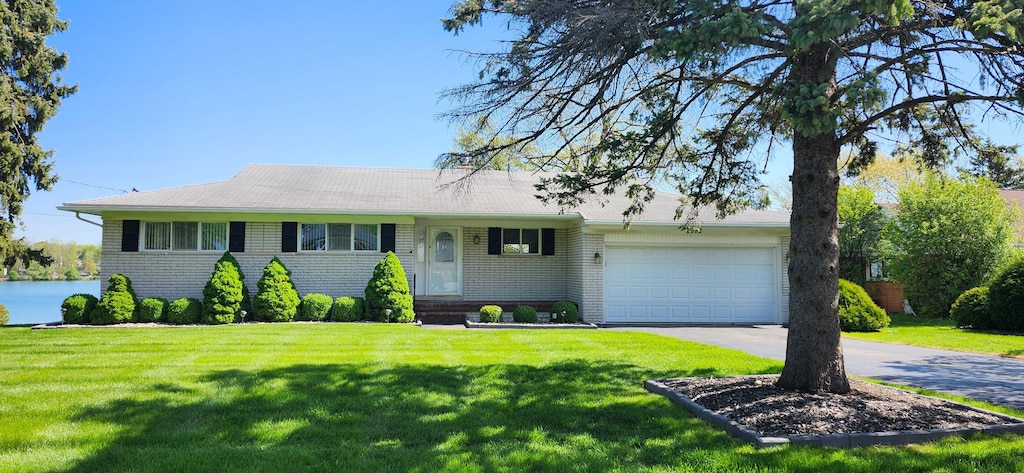 2982 Shawnee Ln, Waterford, MI 48329 - ranch-style house featuring an attached garage, a front lawn, asphalt driveway, and brick siding
