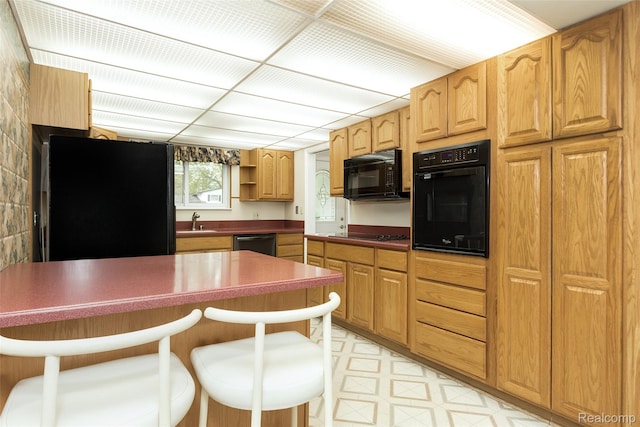 2982 Shawnee Ln, Waterford, MI 48329 - kitchen featuring black appliances, a sink, a kitchen breakfast bar, dark countertops, and open shelves